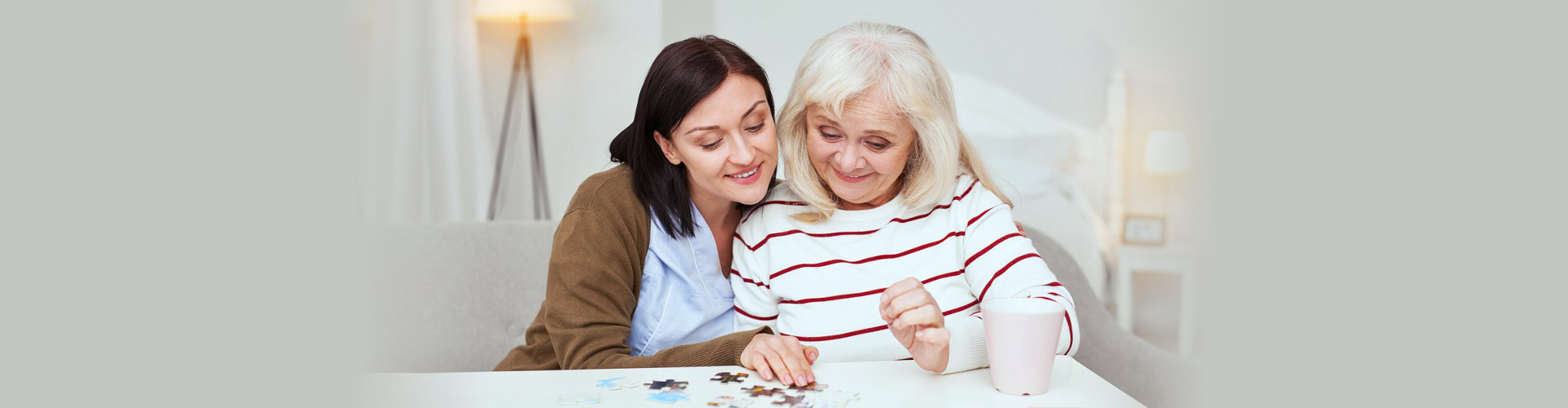 caregiver and senior woman solving the puzzle